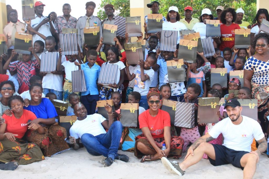 A large group of families and the Goodwill team holding donated parcels