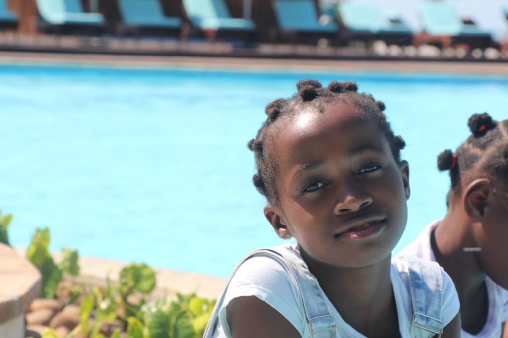 A smiling girl beside a swimming pool on an outing