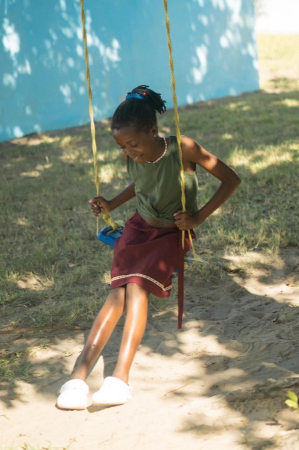A girl on a swing in the garden at Goodwill