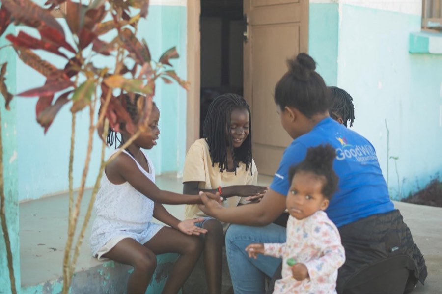 Children and a caregiver in the doorway of the Goodwill home