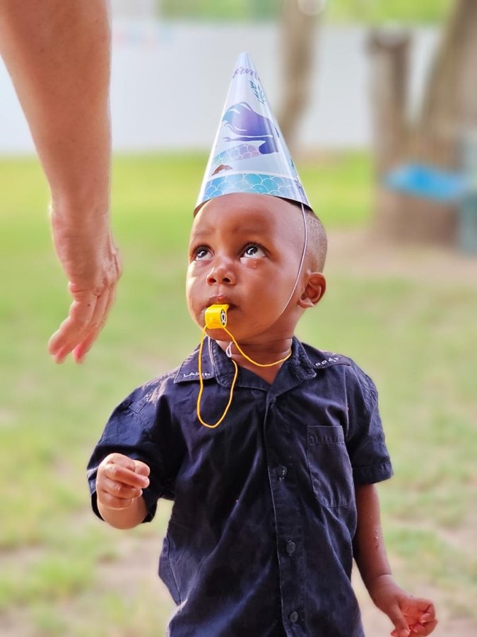 A little boy in a party hat at a Goodwill celebration